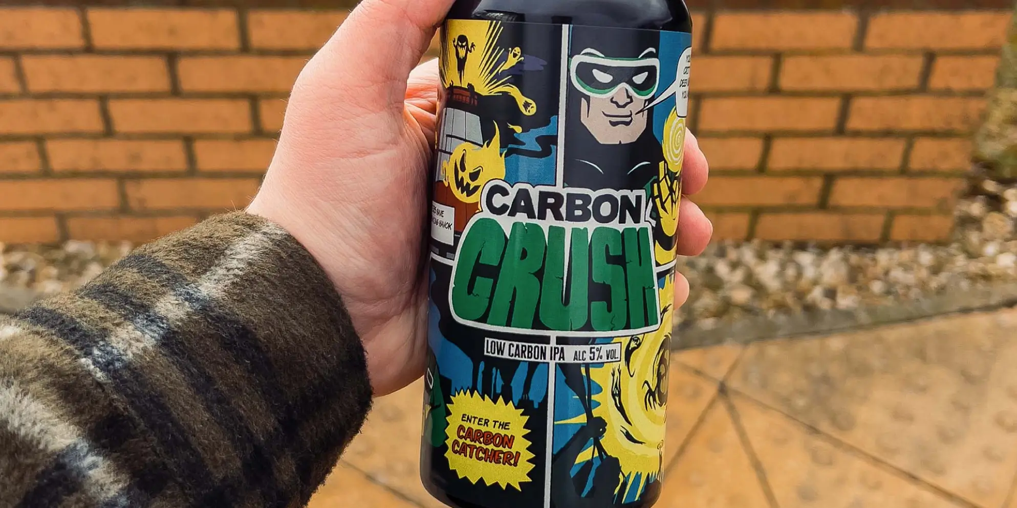 A person raising awareness of industrial decarbonisation by holding up a can of aardvark green.