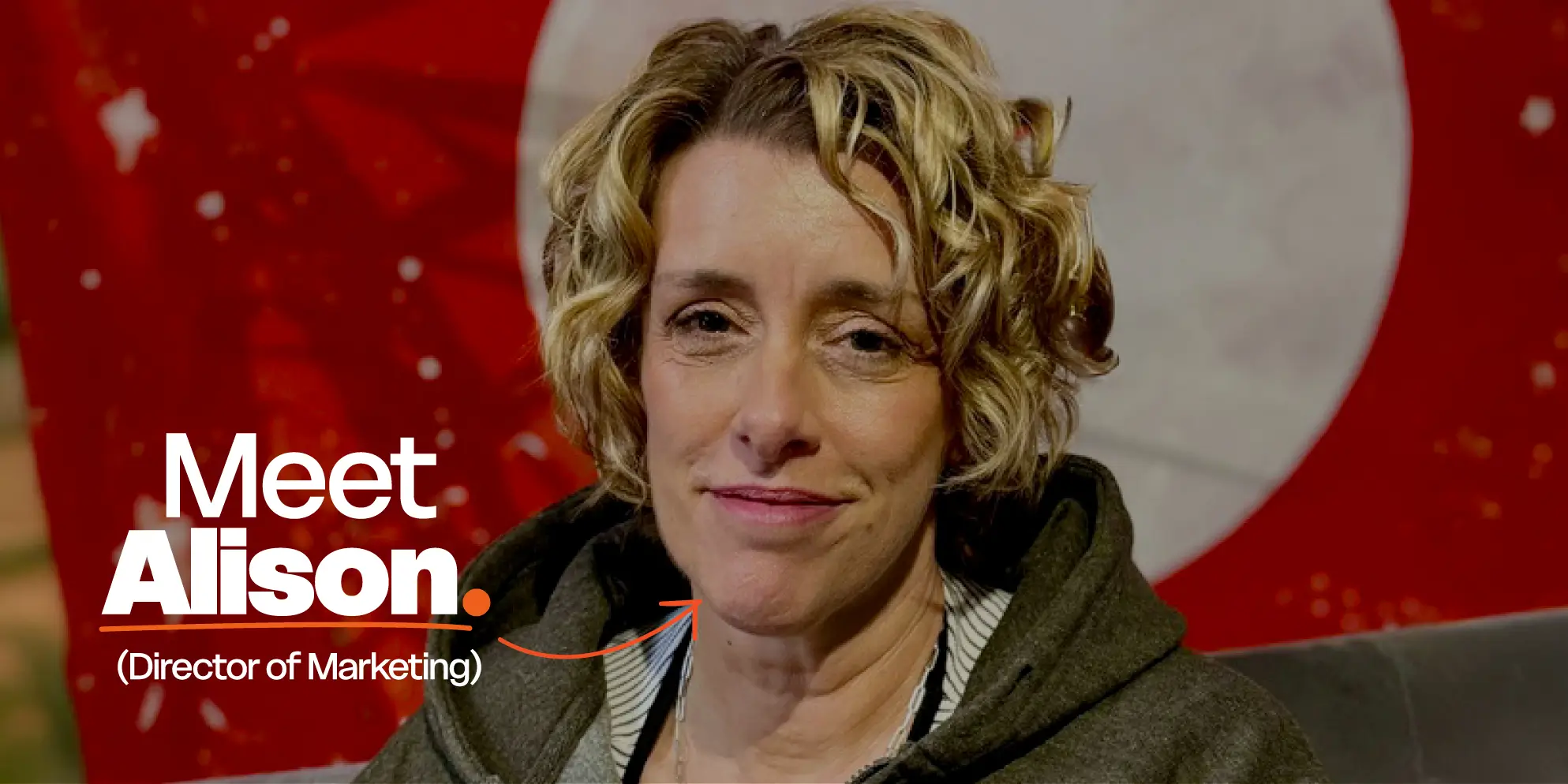 Meet the S4 Team - Sourcefour Marketing Director Alison smiling in the studio in front of the Sourcefour logo on an orange backdrop.