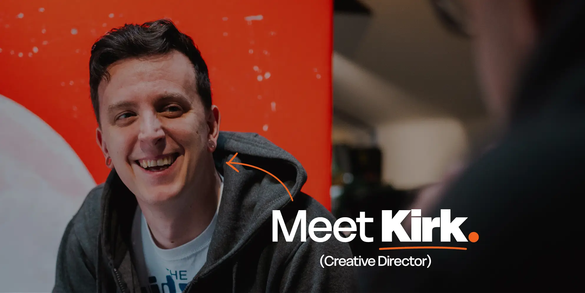 Meet the S4 Team - Sourcefour Creative Director Kirk laughing in the studio on an orange backdrop.